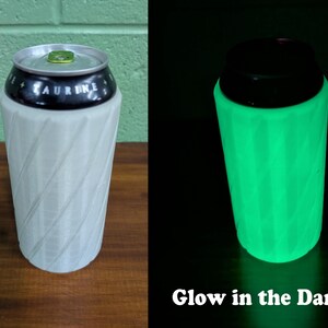 Pu&ograve; includere: Un refrigeratore per lattine bianco con un motivo a spirale e un top nero, che contiene una lattina di bevanda. L'immagine mostra il refrigeratore con luce normale e che si illumina di verde al buio. Il testo sull'immagine recita "Glow in the Dark".