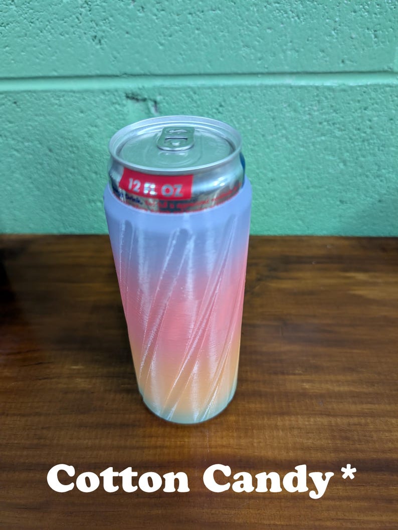 Pu&ograve; includere: Un portabevande color cotone filato con una sfumatura di rosa, arancione e blu. Il portabevande contiene una lattina da 355 ml. Il testo "Cotton Candy" &egrave; in basso nell'immagine.