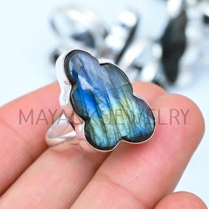 Puede incluir: Un anillo de plata con una piedra preciosa de labradorita azul y verde en forma de nube.