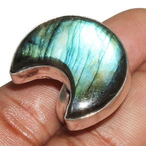May include: A crescent moon shaped ring with a blue and green labradorite gemstone set in sterling silver.