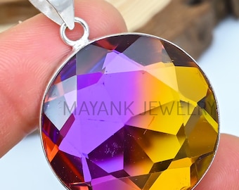 May include: A silver pendant with a round, faceted gemstone. The gemstone is a gradient of purple and yellow.