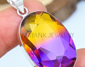 May include: A silver pendant with an oval-cut gemstone. The gemstone transitions from yellow to purple. The pendant is marked with "MAYANK JEWELRY".