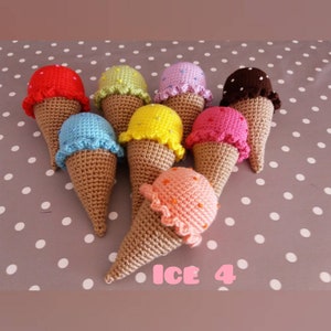May include: A set of eight crocheted ice cream cones in various colors, including red, green, purple, brown, blue, yellow, pink, and orange. The cones are arranged in a circle on a white and gray polka dot background. The text "ICE 4" is written in pink letters below the cones.