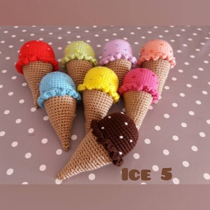 May include: A collection of eight crocheted ice cream cones in various colors, including red, blue, yellow, green, pink, and brown. The cones are decorated with white dots and have a scalloped edge. The text "ICE 5" is visible in the bottom right corner of the image.