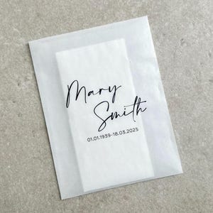 May include: White tissue paper envelope with black text that reads "Mary Smith 01.01.1939-18.03.2025".