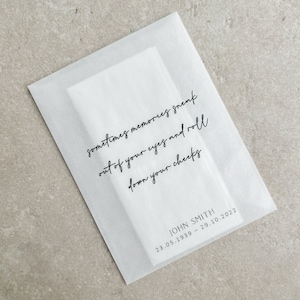 May include: A white translucent paper envelope with the text "sometimes memories sneak out of your eyes and roll down your cheeks." Below the text is "JOHN SMITH 23.05.1939 - 29.10.2022."