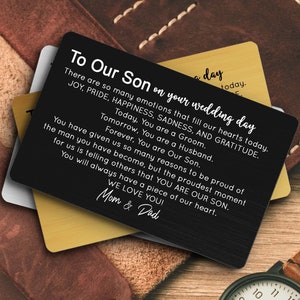 May include: A black metal card with a message to a son on his wedding day. The card reads "To Our Son on your wedding day. There are so many emotions that fill our hearts today. JOY, PRIDE, HAPPINESS, SADNESS, AND GRATITUDE. Today, You are a Groom. Tomorrow, You are a Husband. Forever, You are Our Son. You have given us so many reasons to be proud of the man you have become, but the proudest moment for us is telling others that YOU ARE OUR SON. You will always have a piece of our heart. WE LOVE YOU! Mom & Dad"