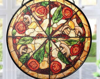 Puede incluir: Una ventana de vitral colgante con un diseño circular de una pizza con champiñones, tomates y pimientos verdes.