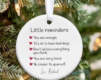 May include: White ceramic ornament with red hearts and the text "Little reminders" followed by a list of positive affirmations. The text "Love, Rechael" is at the bottom of the ornament.