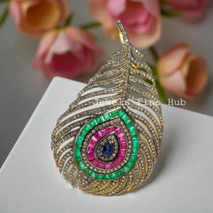 Pingente de pena de pavão cravejado com diamantes naturais, esmeraldas e rubis, em prata de lei 925.