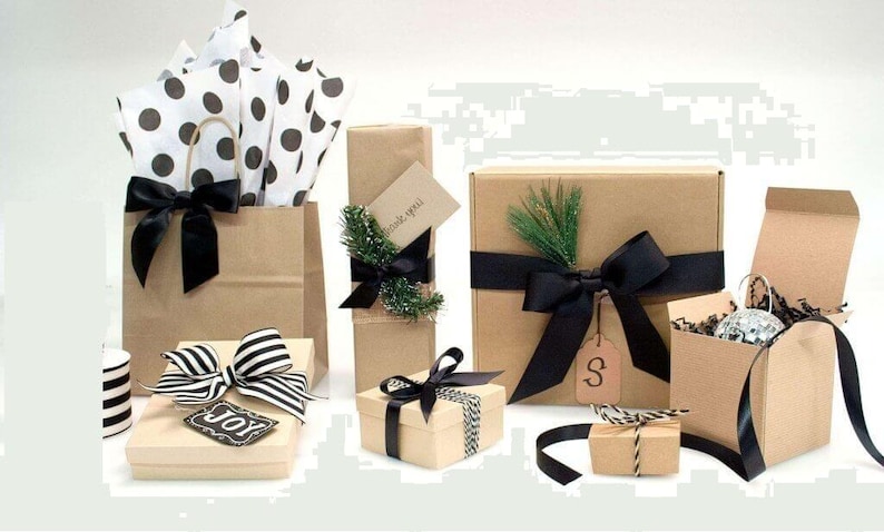 Puede incluir: Una variedad de regalos envueltos en varios tama&ntilde;os y formas. Los regalos est&aacute;n envueltos en papel y cajas marrones, adornados con cintas y lazos negros. Algunos regalos tienen etiquetas decorativas y vegetaci&oacute;n.