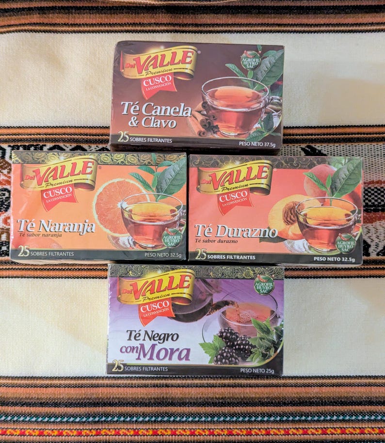 May include: Four boxes of Valle Premium Cusco tea. The boxes are red, white, and green with images of teacups, fruit, and flowers. The tea flavors are: Canela & Clavo, Naranja, Durazno, and Negro con Mora. Each box contains 25 tea bags.