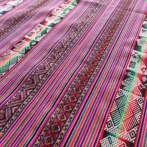 May include: A colorful woven fabric with a repeating geometric pattern. The fabric is made of a variety of colors, including red, blue, green, and white.