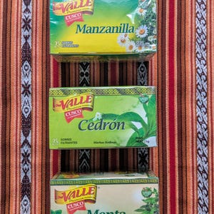 May include: Three boxes of Valle Cusco tea bags. The boxes are green and yellow with a gold border. The tea flavors are Manzanilla, Cedr&oacute;n, and Menta. Each box has a picture of the herb on the front.