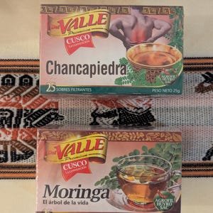 May include: Two boxes of herbal tea bags. The top box is yellow and features a red image of a person with back pain. The text on the box reads "VALLE Premiun CUSCO LA CONVENCI&Oacute;N Chancapiedra 25 SOBRES FILTRANTES AGROFIL HUYRO SAC PESO NETO 25g". The bottom box is yellow and features a green image of a cup of tea. The text on the box reads "VALLE Premiun CUSCO LA CONVENCION Moringa El &aacute;rbol de la vida 25 SOBRES FILTRANTES Hierbas Andinas AGROFIL HUYRO SAC PESO NETO 25g".