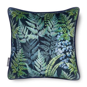 May include: A square scatter cushion featuring a dark navy blue background with a dense, overlapping pattern of fern leaves in shades of light green, teal, and blue. The cushion has a dark blue piped edge and a small grey brand tag on the left side.