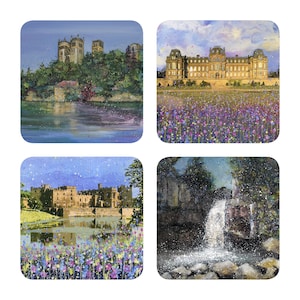 May include: A set of four square coasters, each with a different landscape painting. The images depict a castle on a hill, a stately building with flowers, a castle by a lake, and a waterfall. The paintings use an impressionistic style with bright colours.