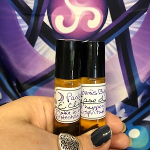 May include: Two small glass bottles with black roll-on tops and labels that say "Pandora's Box Eclipse Oil" and "Make it happen, protect you, spiritual".