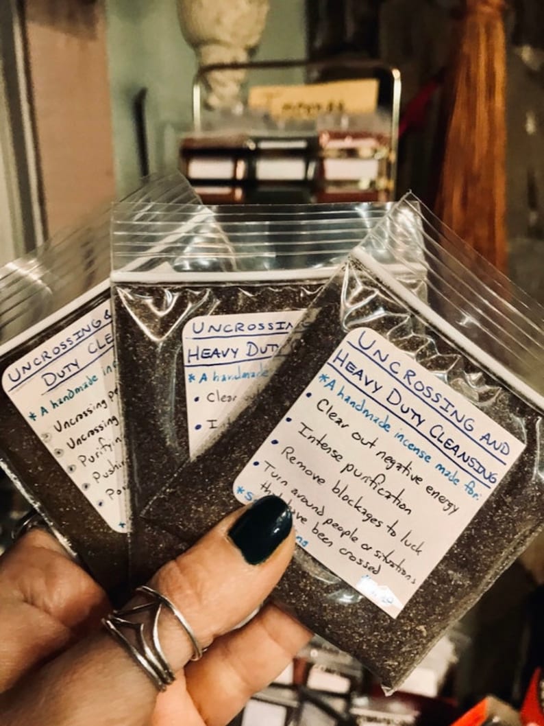Pode incluir: Tr&ecirc;s pequenos sacos de pl&aacute;stico cheios de um p&oacute; castanho escuro. Cada saco tem um r&oacute;tulo escrito &agrave; m&atilde;o que diz "Uncrossing & Heavy Duty Cleansing" e lista os benef&iacute;cios do incenso. Os benef&iacute;cios incluem limpar a energia negativa, a purifica&ccedil;&atilde;o intensa, remover os bloqueios &agrave; sorte e virar as pessoas ou situa&ccedil;&otilde;es que foram cruzadas.