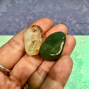 Pode incluir: Duas pedras polidas, uma é uma citrina amarela clara e a outra é uma aventurina verde escura.