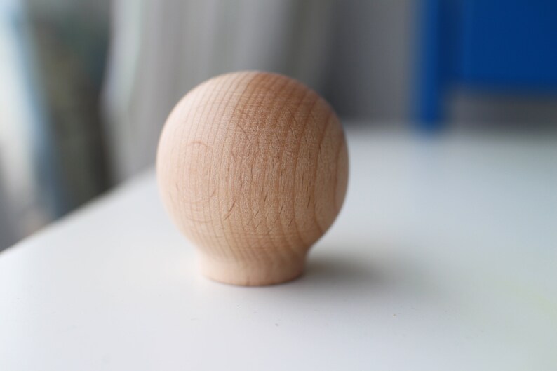 May include: A smooth, round, wooden knob with a light brown color.