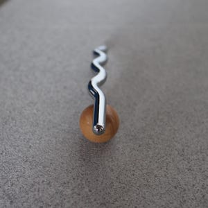 Pu&ograve; includere: Una tazza di ceramica bianca con manico nero e la scritta "But First, Coffee" in nero, in grassetto. La tazza &egrave; su una superficie bianca.