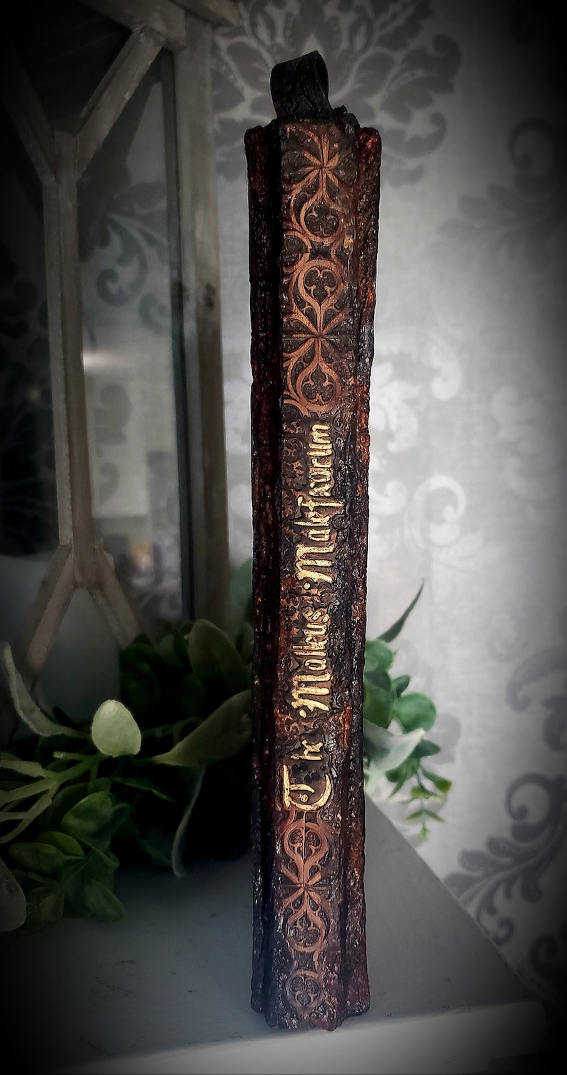 May include: A dark brown book with gold lettering that reads "The Works of William Shakespeare". The book has a decorative design on the spine.