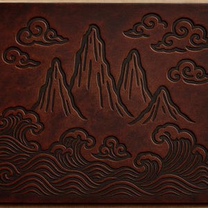 May include: A brown leather panel with an embossed design featuring mountains, clouds, and ocean waves. The artwork has a detailed, textured appearance with dark brown accents, creating a three-dimensional effect. The overall theme is nature and landscape.