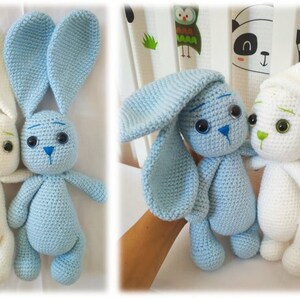 May include: Two crocheted bunny plushies, one white and one light blue, with embroidered eyes and noses. The bunnies are standing side-by-side.