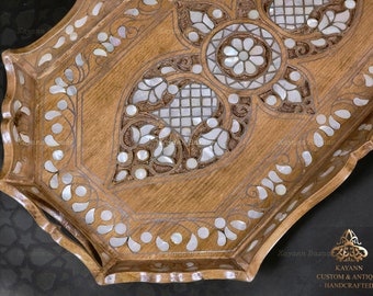 May include: Octagonal wooden serving tray with intricate carvings and mother-of-pearl inlay. The tray has a scalloped edge and two handles. The inlay is in a floral pattern.