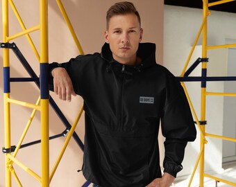 May include: Black hooded anorak jacket with a front zipper and the text "SO DOPE" on the chest. The jacket has long sleeves and a drawstring at the hem. The person is wearing blue jeans.