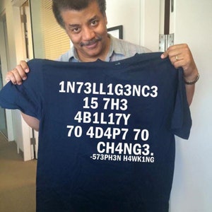 May include: A navy blue t-shirt with white text that reads "1N73LL1G3NC3 15 7H3 4B1L17Y 70 4D4P7 70 CH4NG3. -573PH3N H4WK1NG"