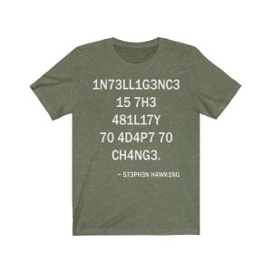 May include: Green t-shirt with white text that reads: "1N73LL1G3NC3 15 7H3 481LL17Y 70 4D4P7 70 CH4NG3. - 573PH3N H4WK1NG"