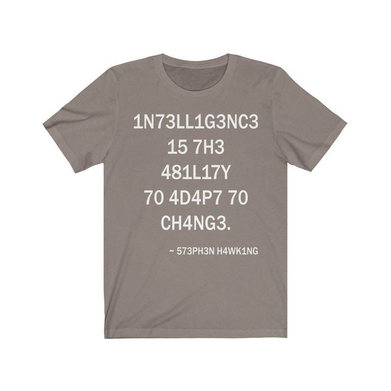 May include: A gray t-shirt with white text that reads "1N73LL1G3NC3 15 7H3 481LL17Y 70 4D4P7 70 CH4NG3. - 573PH3N H4WK1NG"