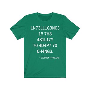 May include: Green t-shirt with white text that reads: "1N73LL1G3NC3 15 7H3 481LL17Y 70 4D4P7 70 CH4NG3. - 573PH3N H4WK1NG"