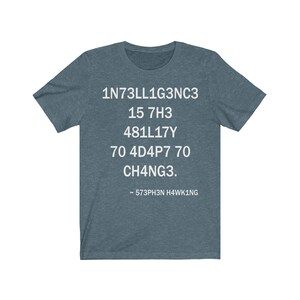 May include: A teal blue t-shirt with white text that reads "1N73LL1G3NC3 15 7H3 481LL17Y 70 4D4P7 70 CH4NG3. - 573PH3N H4WK1NG"