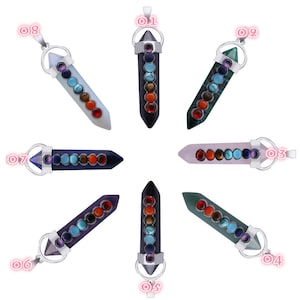 Peut inclure: Huit pendentifs chakra avec des chaînes en argent. Chaque pendentif est d'une couleur différente et comporte sept pierres représentant les sept chakras. Les pendentifs sont disposés en cercle.
