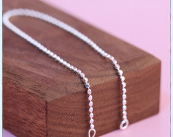 Può includere: Una collana a catena d'argento con un delicato design a perline. La catena è composta da piccole perline rotonde che sono equidistanti.