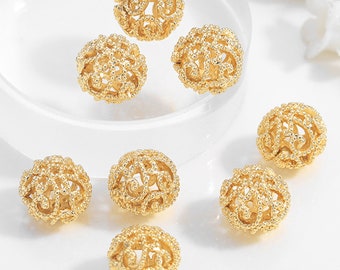 May include: Eight gold-colored metal beads with a delicate filigree design. The beads are round and have a hollow center.