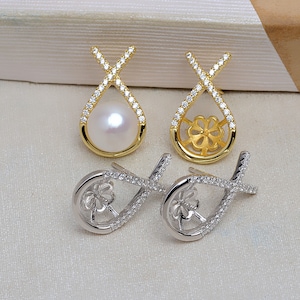 May include: Three pairs of earrings. One pair features a white pearl in a gold teardrop-shaped setting with a crisscross design encrusted with small clear stones. The second pair is gold with a flower design. The third pair is silver.