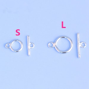 May include: Two silver toggle clasps, one labeled "S" and the other labeled "L".