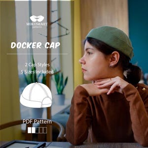 May include: Image of a green docker cap. The text "DOCKER CAP" is displayed in large, bold letters. Below the text, it reads "2 Cap Styles, 5 Sizes Included". A line drawing of a docker cap is also shown. The text "PDF Pattern" is displayed at the bottom.