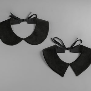 May include: Two black velvet Peter Pan collars with a matching black ribbon tie. The collars are displayed on a gray background. The collars have a soft, rounded shape.
