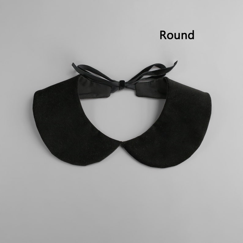 May include: A black, round collar with a bow tie closure. The collar is made of a soft, velvety material. The word "Round" is printed in black on the top right of the image.