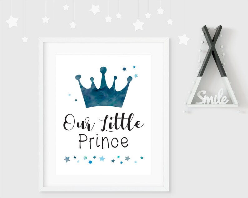 K&ouml;nnte beinhalten: Ein wei&szlig;er gerahmter Druck mit einer blauen Aquarellkrone und dem Text "Our Little Prince" umgeben von blauen und wei&szlig;en Sternen.