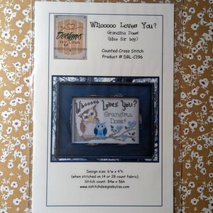 May include: Counted cross stitch pattern featuring two owls with the text "Whooooo Loves You? Grandma Does!" The pattern is 6 inches wide by 4 inches high and is stitched on 14 or 28 count fabric. The stitch count is 84 stitches wide by 56 stitches high.