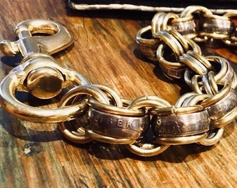 May include: A gold chain keychain made from US Liberty Dollar coins. The chain has a large gold clasp.