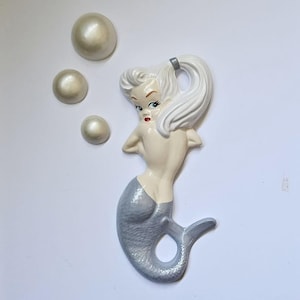 Puede incluir: Una taza de cerámica blanca con un asa negra y el texto "But First, Coffee" en negrita negra. La taza está sobre una superficie de madera. La taza mide aproximadamente 10 cm de alto.