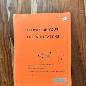 May include: An orange book titled "FLOWER UP YOUR LIFE WITH TATTING!" features floral designs, uncommon patterns, and philosophical thoughts. The cover includes a floral illustration and the author's name, Marie Benge Craig.