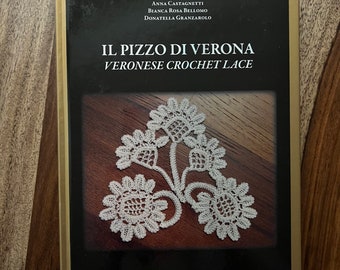 May include: A book with a gold border, titled "IL PIZZO DI VERONA VERONESE CROCHET LACE". The cover displays a white crochet lace design on a dark brown background. The authors' names are listed above the title.